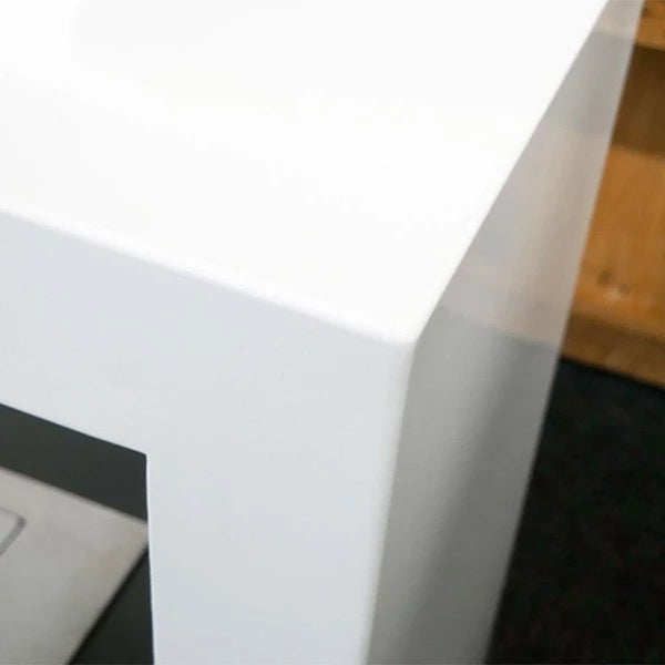 Close-up of a sleek white tabletop edge, showcasing modern design and clean lines.