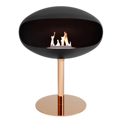 Cocoon Pedestal Black bioethanol fireplace with copper base, modern design and manual burner for stylish heating.
