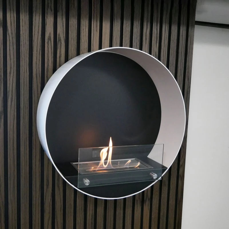 Round white wall mounted bioethanol fireplace with glass and black interior, displaying vibrant orange flames.