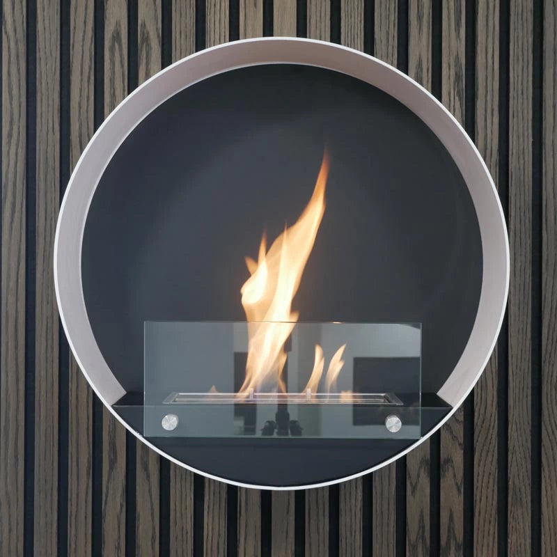 Contemporary round white wall mounted bioethanol fireplace with flame, enhancing modern interior design.